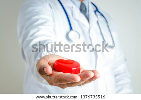 Health check doctor In the hand there is a red heart placed