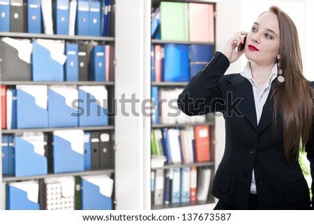 young business woman talking at the phone on office background