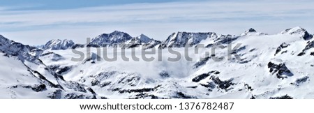 Panoramic view of the snowy mountains with a cloud resembling a waterfall