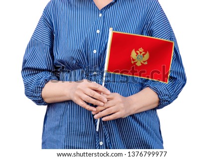 Montenegro flag. Close up of woman's hands holding a national flag of Montenegro isolated on white background.