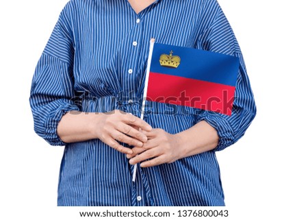 Liechtenstein flag. Close up of woman's hands holding a national flag of Liechtenstein isolated on white background.