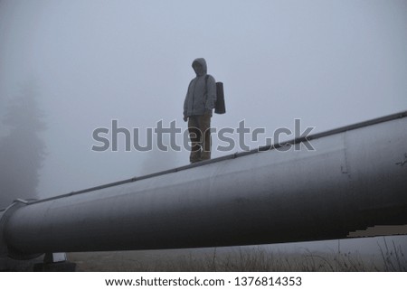 man standing on a pipe