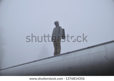 man standing on a pipe