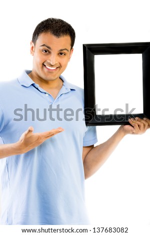 Handsome young man pointing at picture frame, isolated on white background