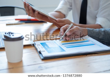 man holding pen to point in paperwork, meeting concept