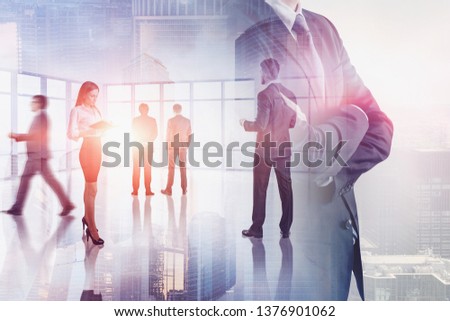 Business people working in panoramic office with double exposure of confident business leader and cityscape. Concept of teamwork. Toned image blur