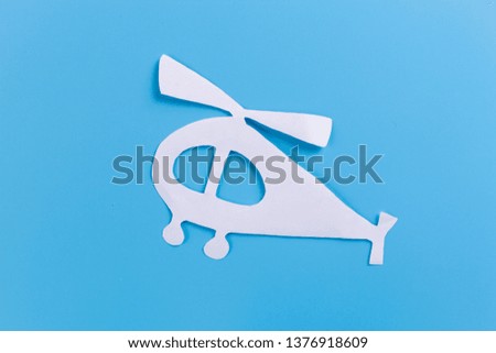Helicopter in flight on blue background. paper cut