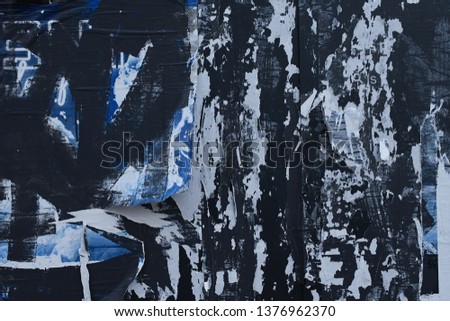 grimy urban dirty ripped street posters on a black painted wood panel  
