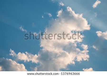 white fluffy clouds in the blue sky and sunshine. clear blue sky with plain white cloud with space for text background. 