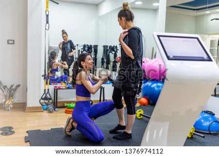 Working together to improve muscle strength and tone. Athletic woman during functional workout with electric muscle stimulation in fitness gym