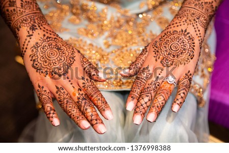 Indian bride's showing mehndi design and wedding ring Royalty-Free Stock Photo #1376998388