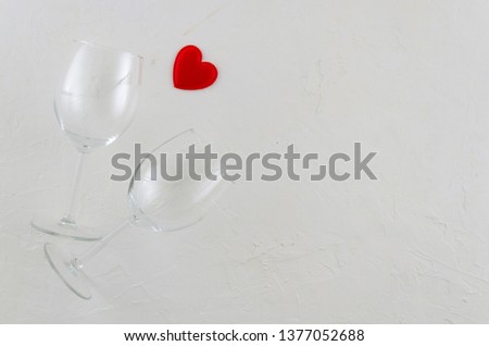 Flat lay romantic concept with two wine glasses and red heart on white isolated background. Space for greeting card or text banner