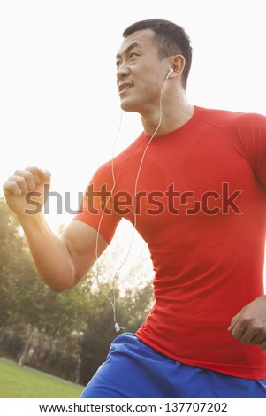 Muscular Man Running and Listening to Music