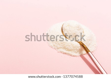 Collagen powder on pink background. Extra protein intake. Natural beauty and health supplement for skin, bones, joints and gut. Plant or fish based. Flatlay, top view. Copy space for your text. Royalty-Free Stock Photo #1377074588