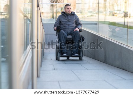 Man in a electric wheelchair using a ramp Royalty-Free Stock Photo #1377077429