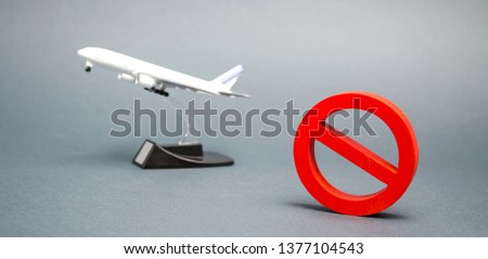 The sign of the ban and a miniature toy aircraft. Ban on flights of civil aircraft. Forbidden zone. Stop symbol. Bans on airport construction. Plane. Night flights. Law. Prohibition Royalty-Free Stock Photo #1377104543