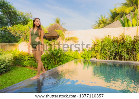 Portrait beautiful young asian woman smile happy relax and leisure in the swimming pool hotel resort for travel and vacation concept