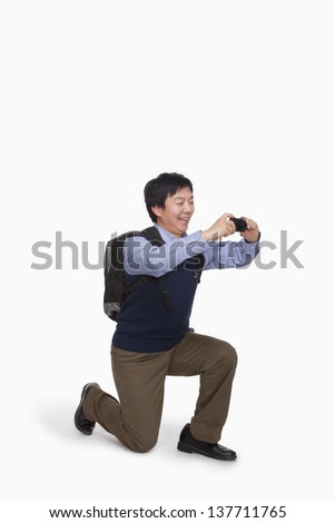 Young man taking picture with digital camera