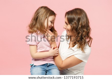 Woman in light clothes have fun with cute child baby girl. Mother, little kid daughter isolated on pastel pink wall background, studio portrait. Mother's Day love family, parenthood childhood concept