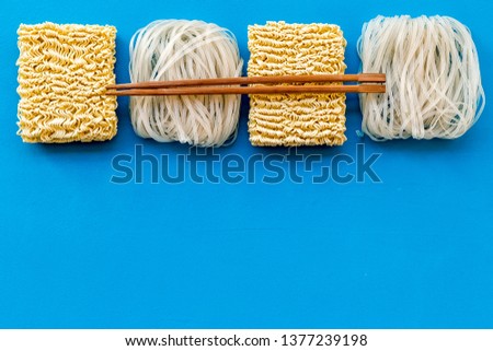 Chinese and Japanese food cooking with rice vermicelli, noodles and sticks on blue background top view mockup