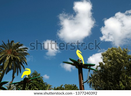 Two yellow toucans. Wooden birds decorating children recreation area.