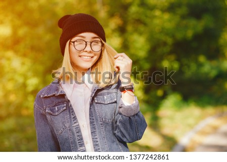young and pretty girl standing in a summer park 