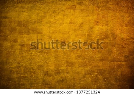 The brass concrete surface glows from the walls of a temple in Thailand.Pattern and surface of golden concrete walls