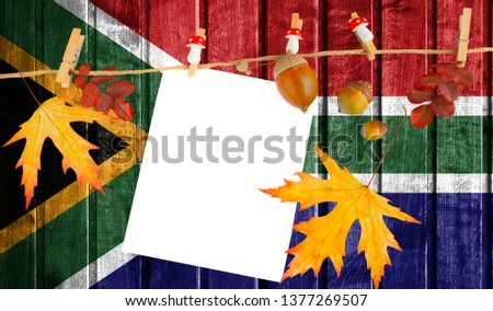 South Africa flag on autumn wooden background with leaves and good place for your text.