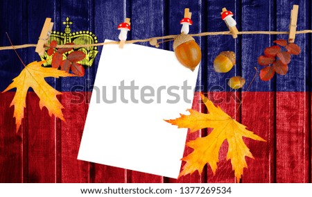 Liechtenstein flag on autumn wooden background with leaves and good place for your text.