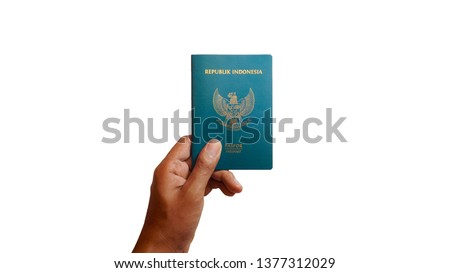 Close up hand holding indonesian passport isolated on white background - Image Royalty-Free Stock Photo #1377312029