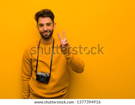 Young photographer man showing number two