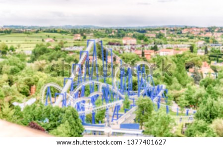 Defocused background of a rollercoaster inside an amusement park. Intentionally blurred post production for bokeh effect