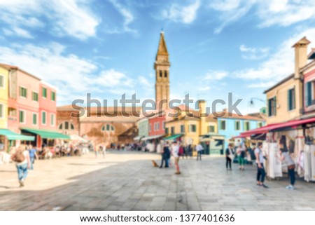 Defocused background of tourists walking on the main square of Burano island, Venice, Italy. Intentionally blurred post production for bokeh effect