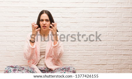 Young woman wearing pajama angry and upset