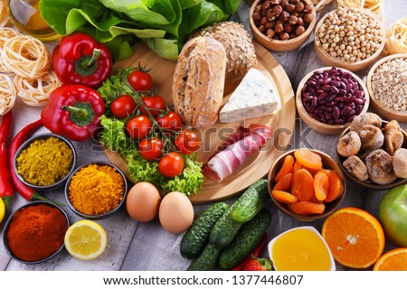 Composition with assorted organic food products on wooden kitchen table. Royalty-Free Stock Photo #1377446807
