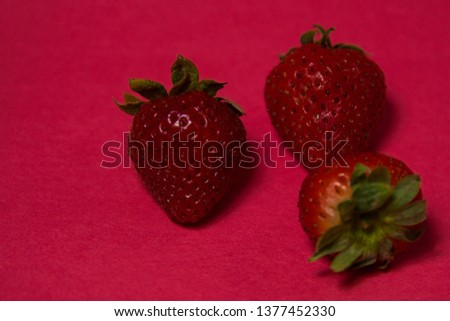 Tasty red strawberries on a red background.