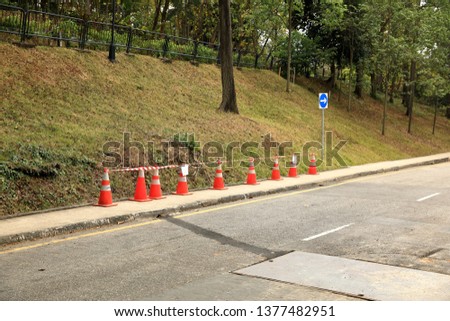 row of orange fluorescent, reflex traffic cones on road
