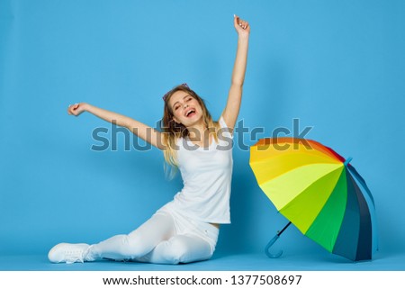    joyful woman sitting on the floor with an umbrella                           