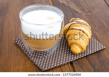 Cappuccino in glass cup with croissant for lunch. Studio Photo