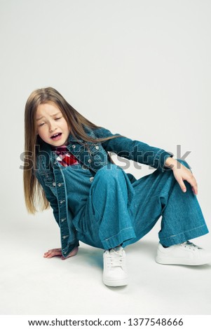 the little girl fell. Kid shows emotion hurt. frustrated child. Studio photography.