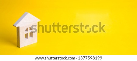 Wooden house on a yellow background. Concept of buying and selling housing, building a house. Rent of apartments. Realtors. Real estate, private property, repair and renovation. banner