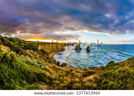 Travel to Australia. Early morning on the ocean shore. Pink dawn clouds over the famous rocks "Twelve Apostles". The concept of active, ecological and photo tourism