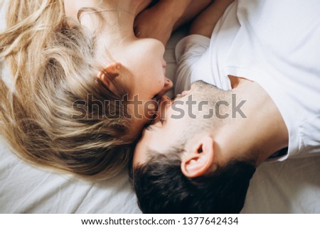 Lovers hug in the morning in a white bed