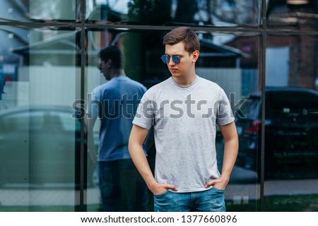 A stylish man in a gray  T-shirt. Street photo