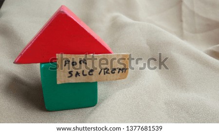 Conceptual Close up Element Design for Property, asset Advertising, for Rent or Sale, Red and Green House at land with wooden plank with copy space for text placement