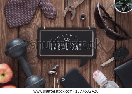 Happy Labor Day Fitness and healthy active wellness lifestyle background concept. Gentleman's accessories, dumbbells, and apples on wooden background.