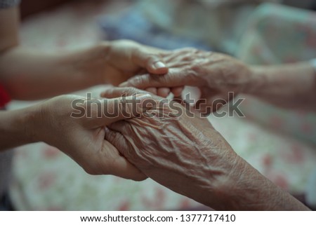 Senior and young holding hands 