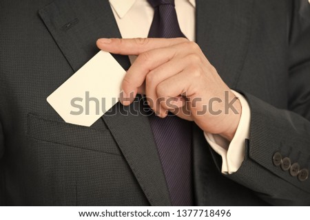 Custom debit card design. Male hand put plastic blank white card to pocket classic suit jacket. Business man carries credit card. Banking services for business. Custom design making your card unique.