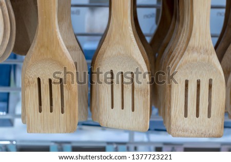 Close-up pictures of wooden ladle containers and hanging holes in a department store.