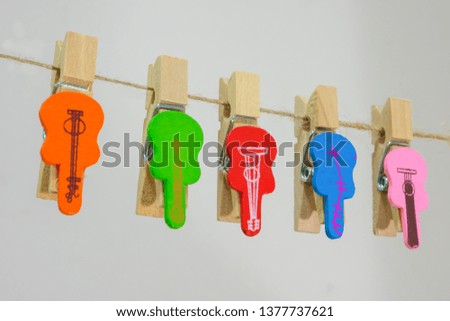 Clothespins with colorful guitar on white background.  